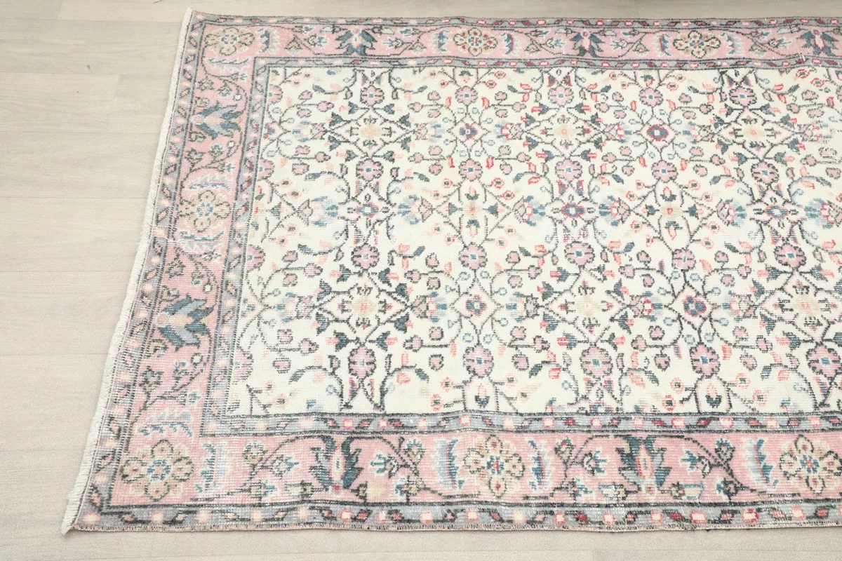 Another angle showing the rug's pattern and border, highlighting the rose and blue colors