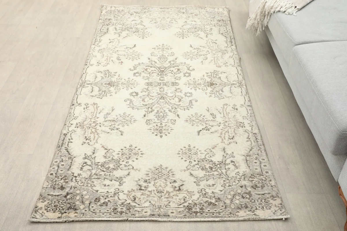 Overhead view of the ivory and gray rug in a room setting next to a sofa