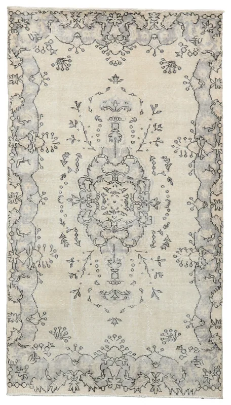Full overhead view of the 4x7 ivory and charcoal vintage Anatolian area rug on a white background.