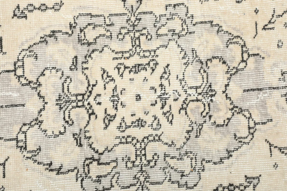 Macro shot of the central charcoal medallion pattern, showing the weave and subtle color variations.