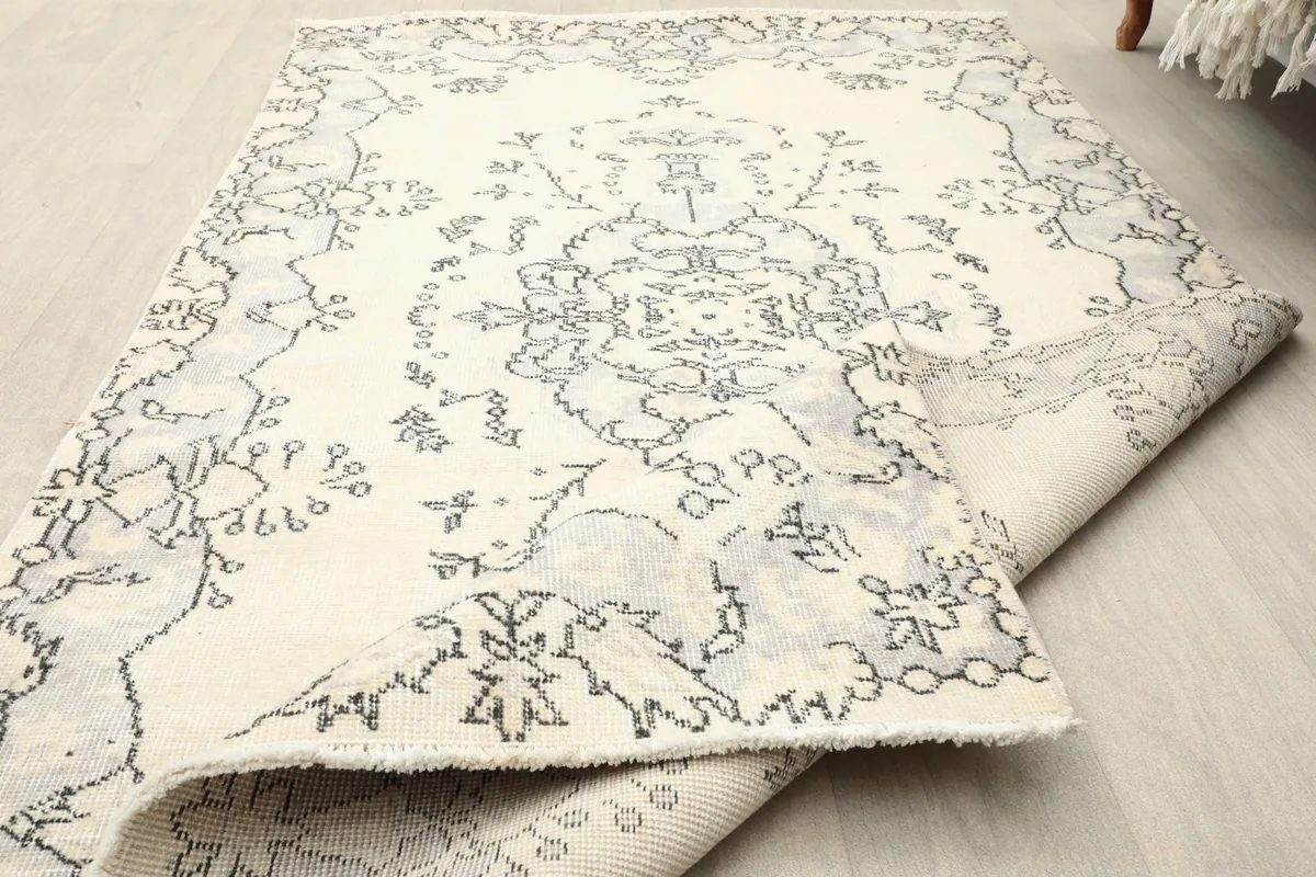 Close-up of the rug's surface, showing the low wool pile and the texture of the vintage material.
