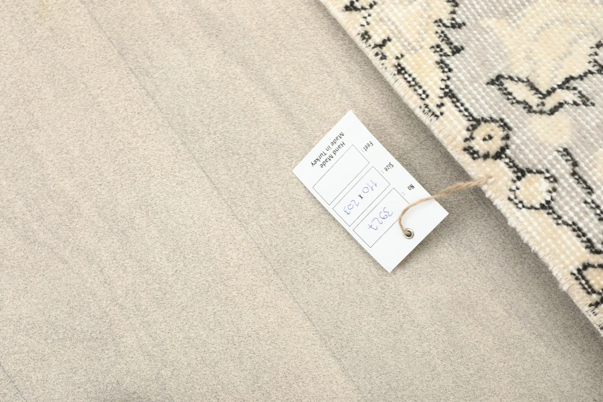 Image showing the product tag with size and item number, placed next to the rug on a light floor.