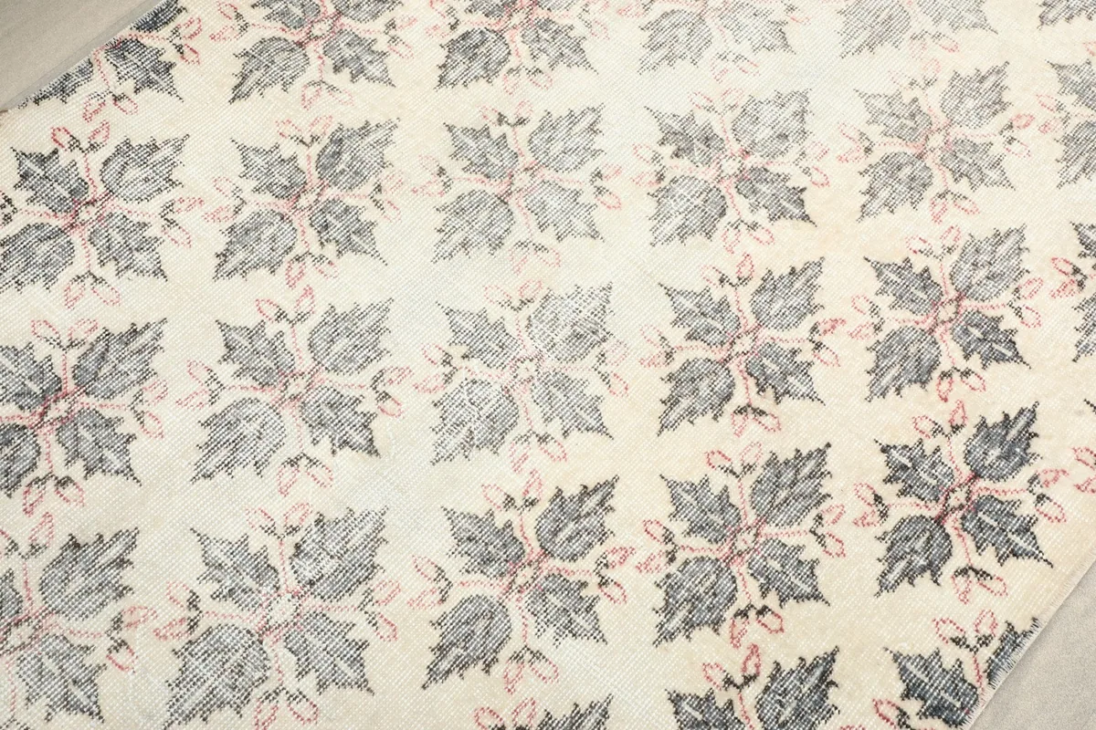 Close-up detail of the ivory field with gray and pink floral motifs