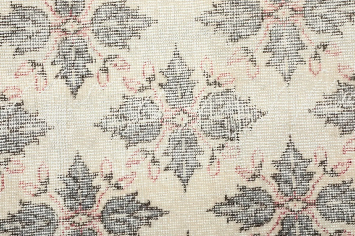 Detailed view of the hand-knotted wool pile and intricate floral pattern