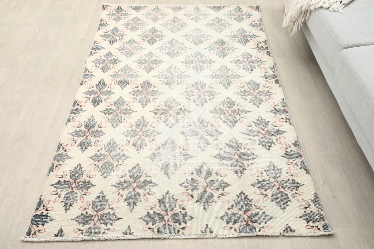 Overhead angled view of the small vintage rug on a light floor