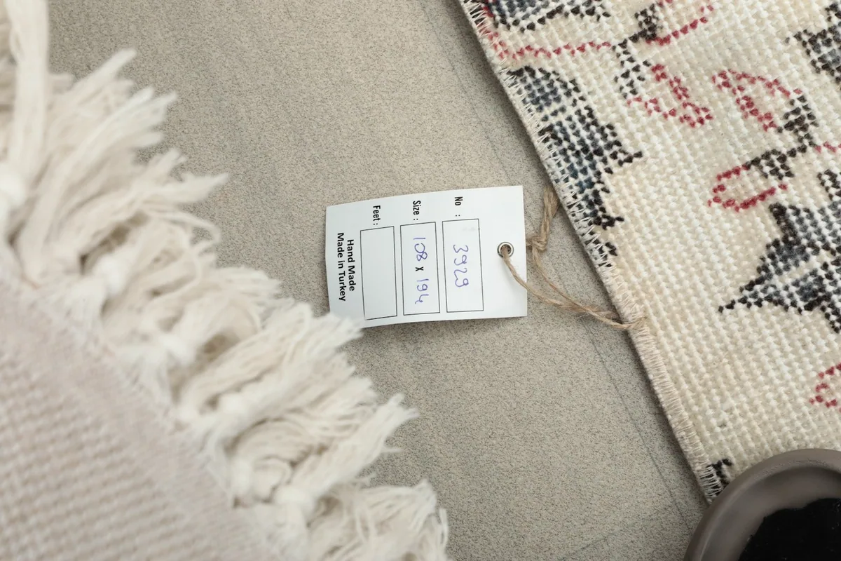 Product tag displaying the rug's dimensions and origin next to the fringe