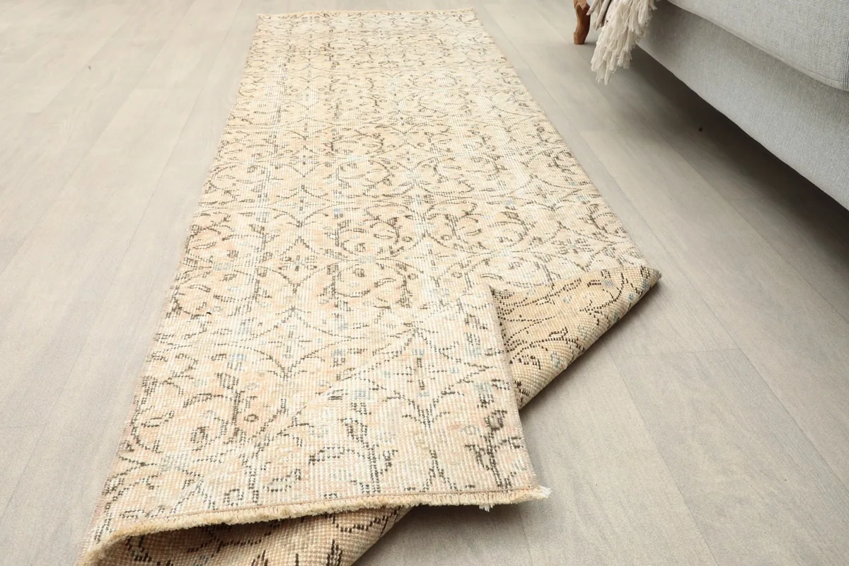 Angled view of the runner partially folded, showing the full length of the rug in a room setting.