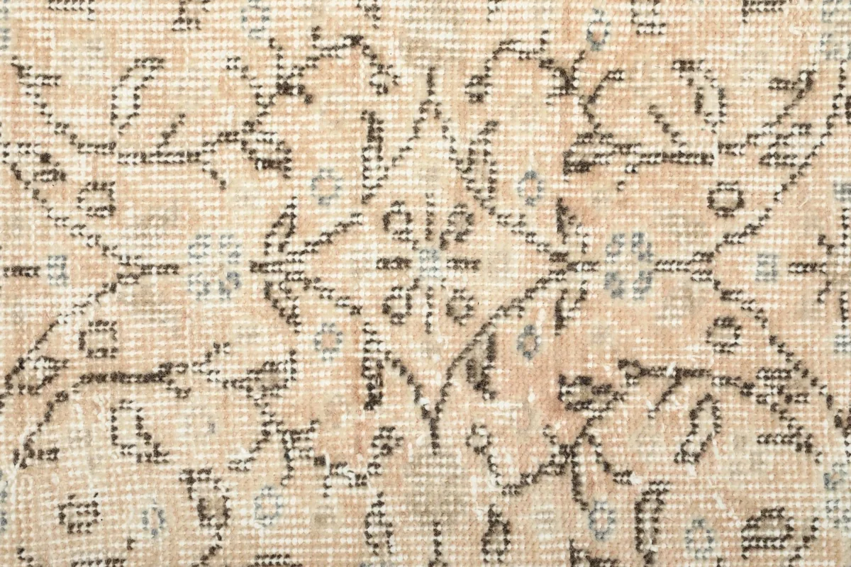 Extreme close-up of the hand-knotted wool pile, showing individual knots and subtle color shifts.