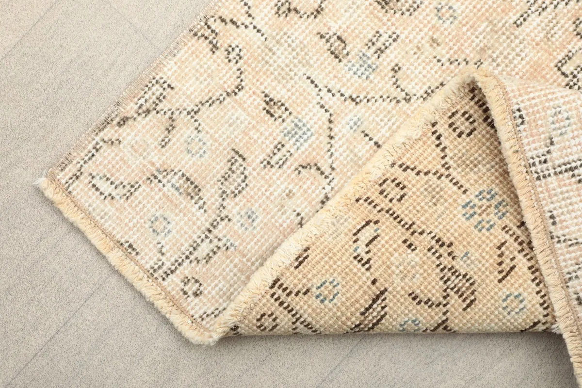Corner of the runner folded to reveal the cotton foundation and the reverse side of the rug.