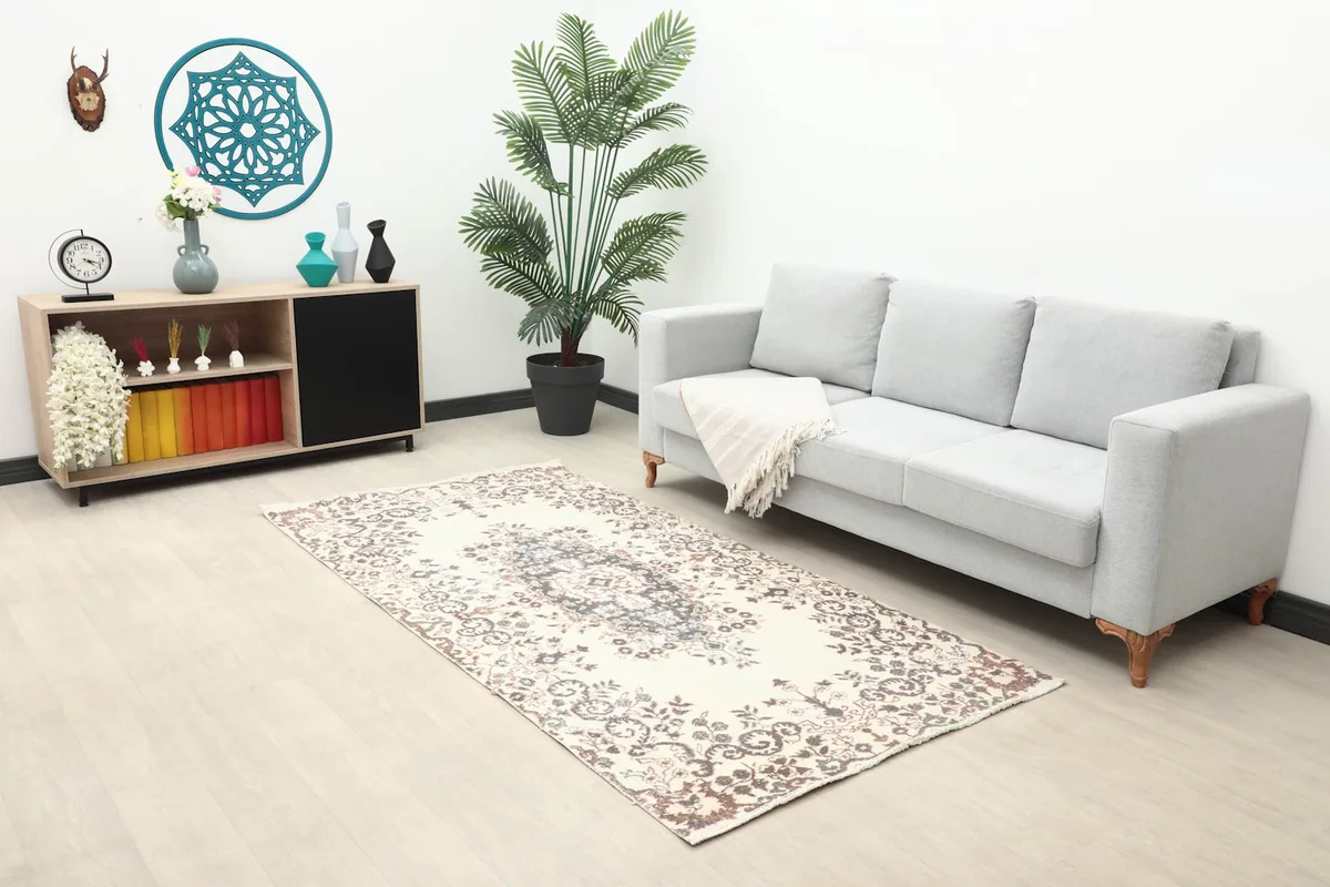 Ivory and charcoal rug placed in a living room setting with a light gray sofa and modern decor