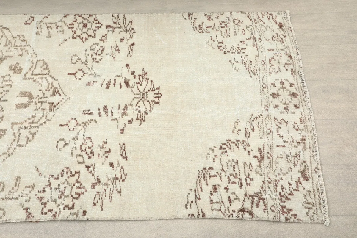 Close-up of the runner's end section, revealing the border and corner design with brown motifs