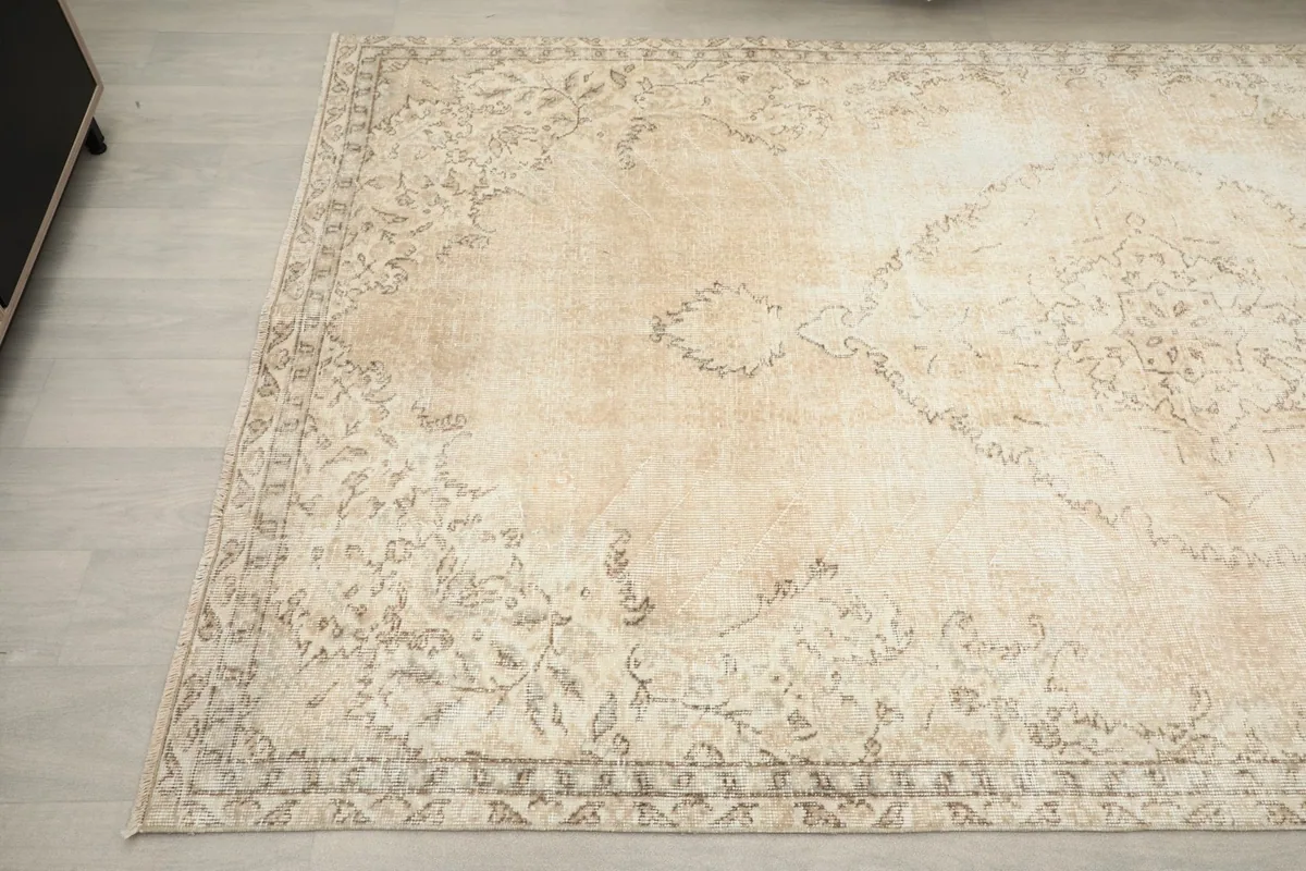 Detailed view of the faded tan patterns and natural patina on the rug surface