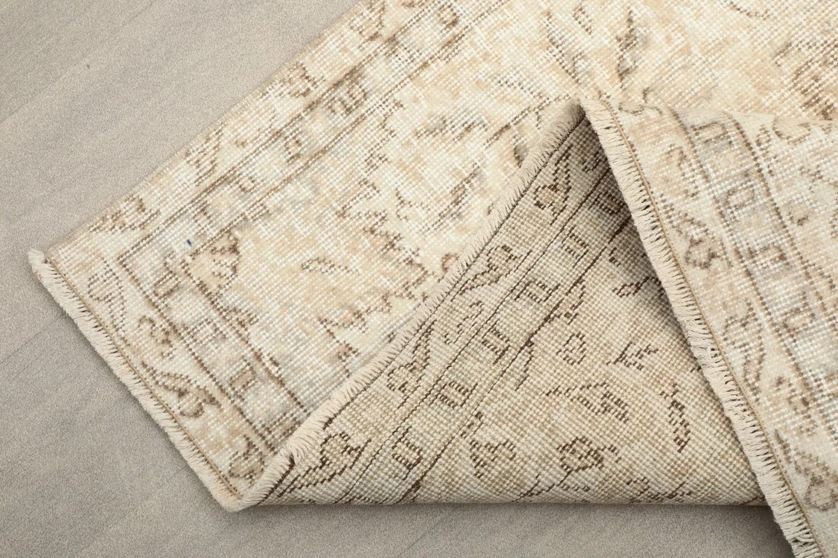 Another view of the back of the rug, revealing the knotting and fringe