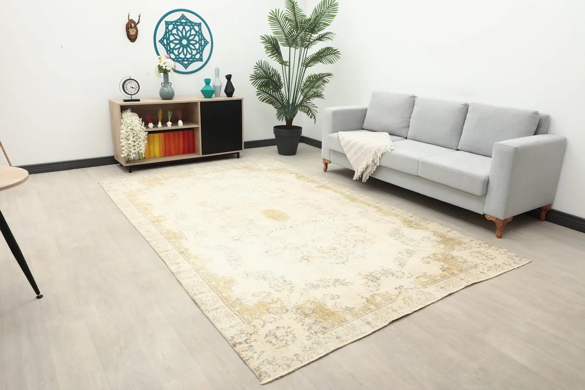 Wide angle view of the ivory and olive vintage rug in a living space, showcasing its large size.