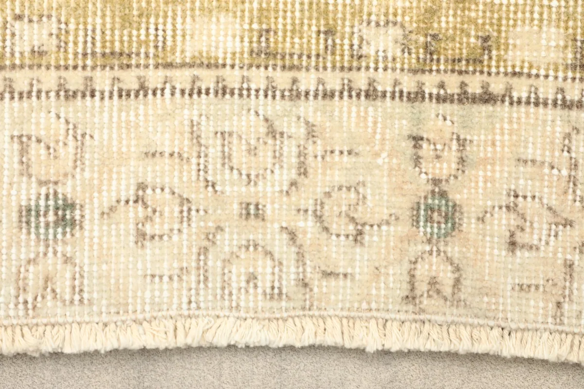 Close-up of the rug's border pattern and fringe, showing the hand-knotted wool texture.
