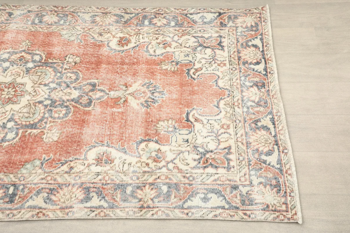 Close-up view of the rug's border design featuring ivory and blue patterns