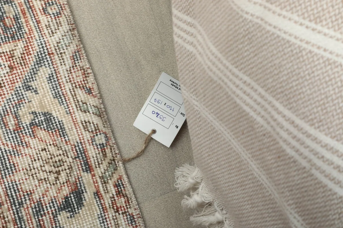 Product tag on the rug, showing details next to a soft blanket