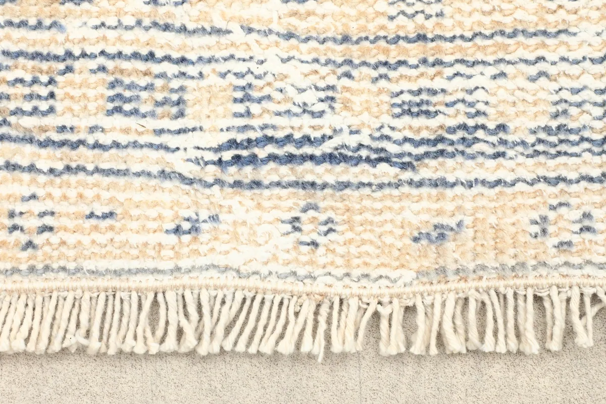 Close-up detail of the fringe and the edge of the hand-knotted wool rug