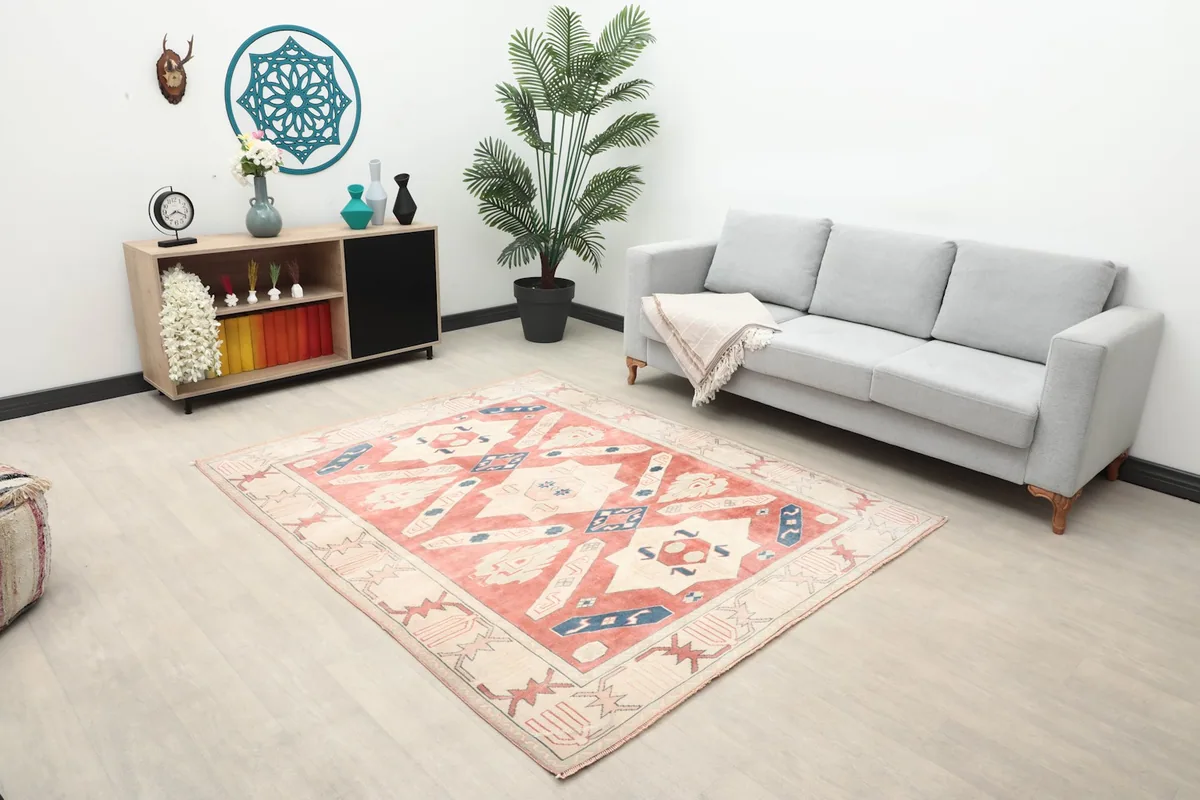 Vintage Anatolian rug displayed in a living room with a gray sofa and wooden cabinet