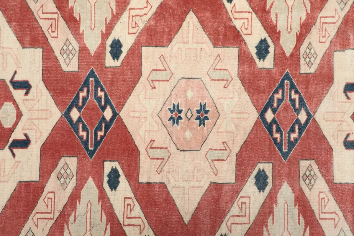 Detailed view of the central geometric motif with red, ivory, and blue colors