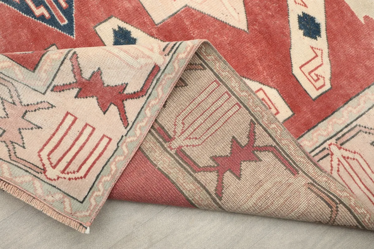 View of the rug's underside and folded edge, revealing the cotton foundation