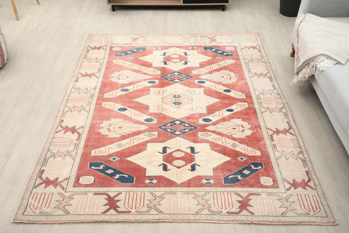 Overhead view of the red, ivory, and blue vintage rug placed in a room setting