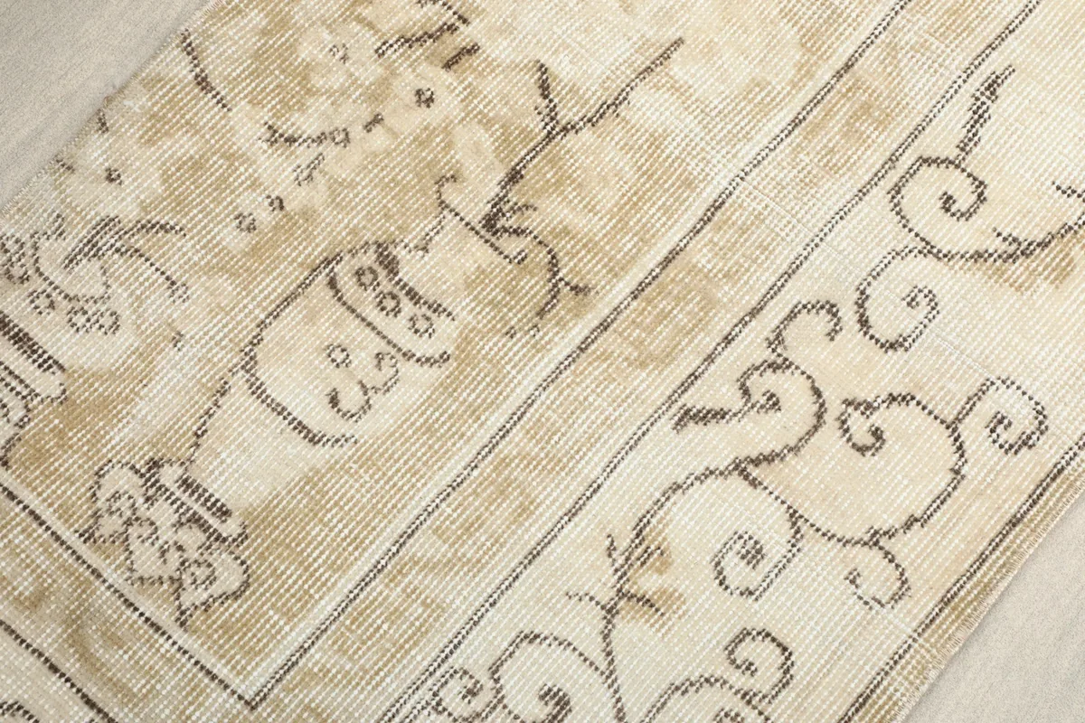 Close-up of the central panel design with brown motifs on a beige background.