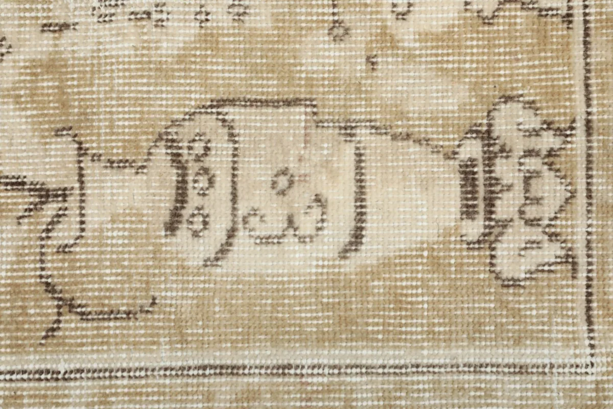 Extreme close-up of a vase motif within the rug's design, showing the intricate knotting and color fading
