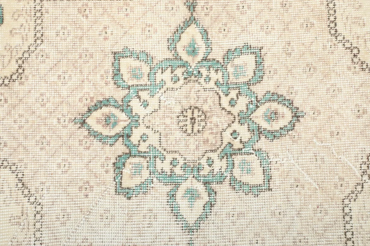 Close-up of the rug's central floral medallion, showcasing the hand-knotted texture.