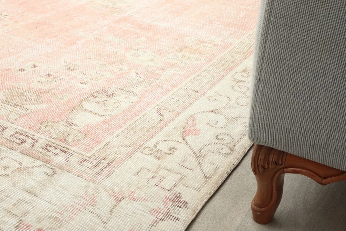 Partial view of the rug extending under a furniture piece, showcasing its placement in a room.