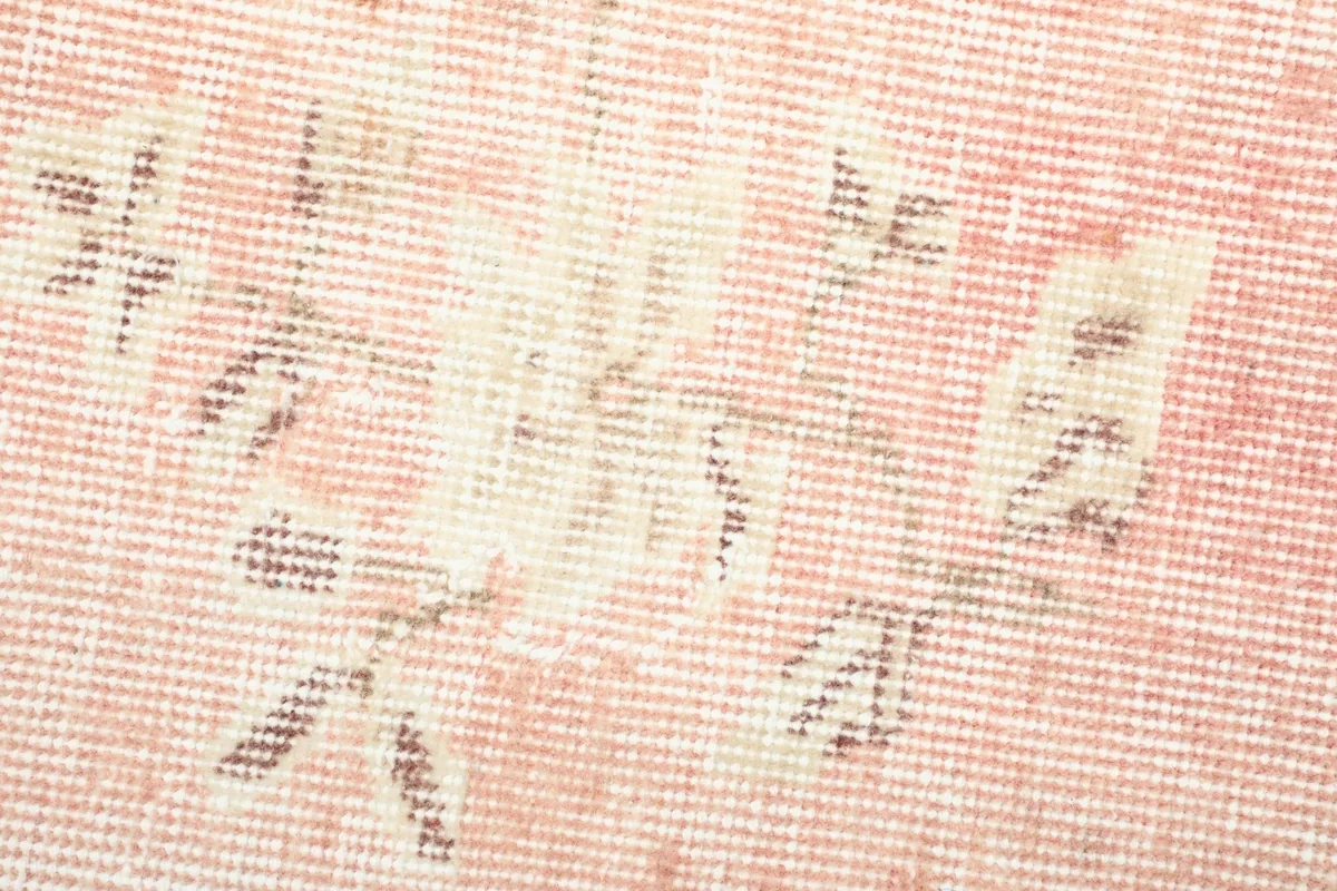 Close-up of a floral motif, revealing the hand-knotted wool texture and color variations.