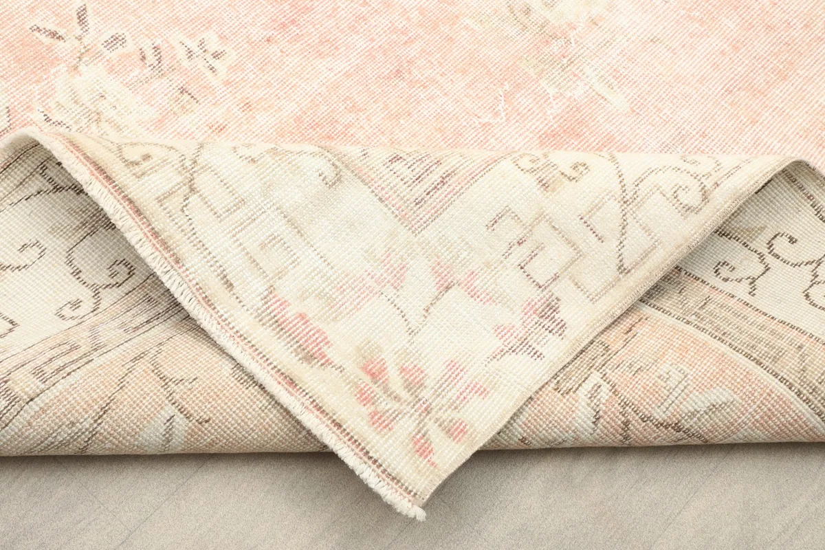 Folded corner of the rug, displaying the reverse side and the hand-knotted structure.