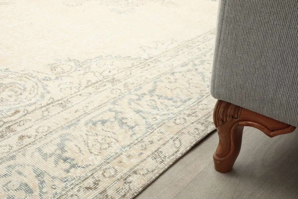 Detail of the rug's border next to the leg of a sofa, showing how it complements the decor