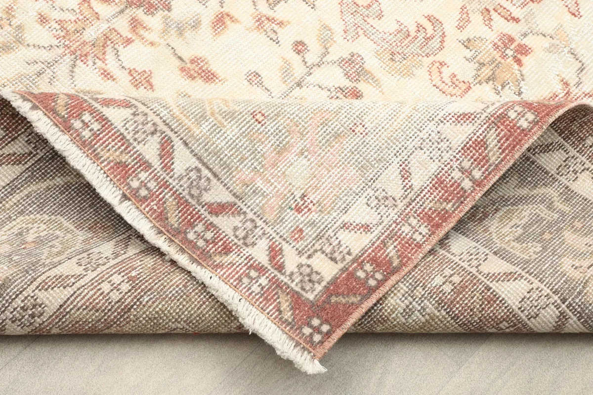 Flipped corner revealing the cotton foundation and reverse side of the hand-knotted rug