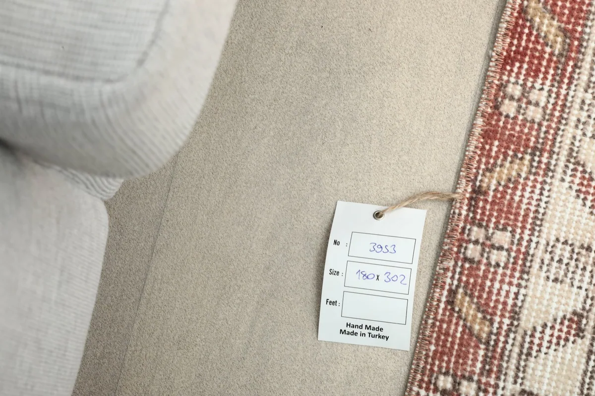 Size tag attached to the rug, showing dimensions 180 x 302 cm and 'Hand Made in Turkey'