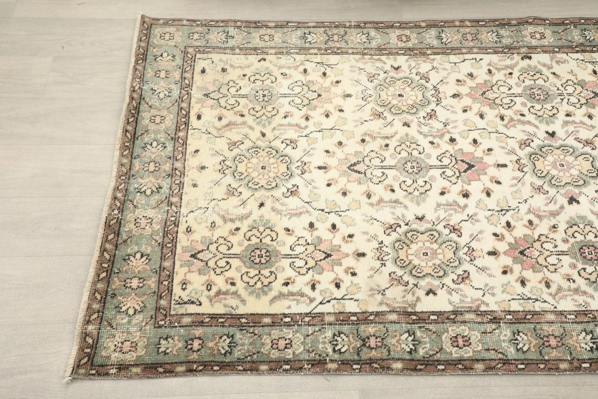 Detailed angle view of the vintage rug highlighting the floral motifs and border
