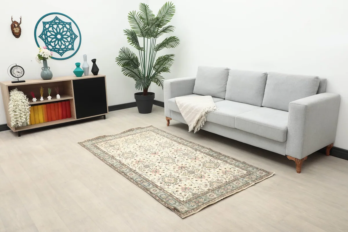 Ivory vintage rug placed in a living room next to a gray sofa