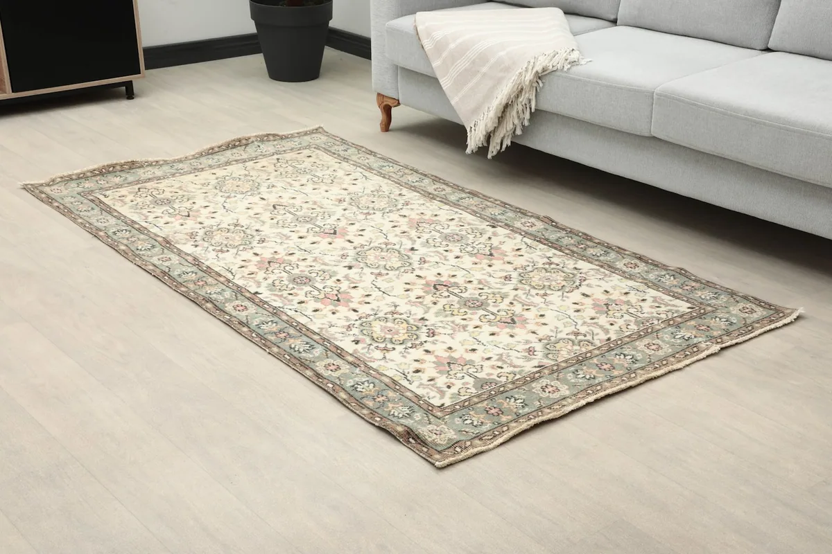 Angle view of the ivory vintage rug on a light floor in a modern room
