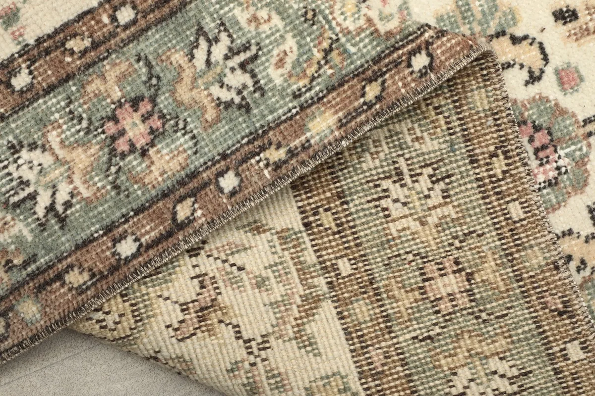 Close-up of the back of the vintage rug, revealing the wool pile and cotton foundation