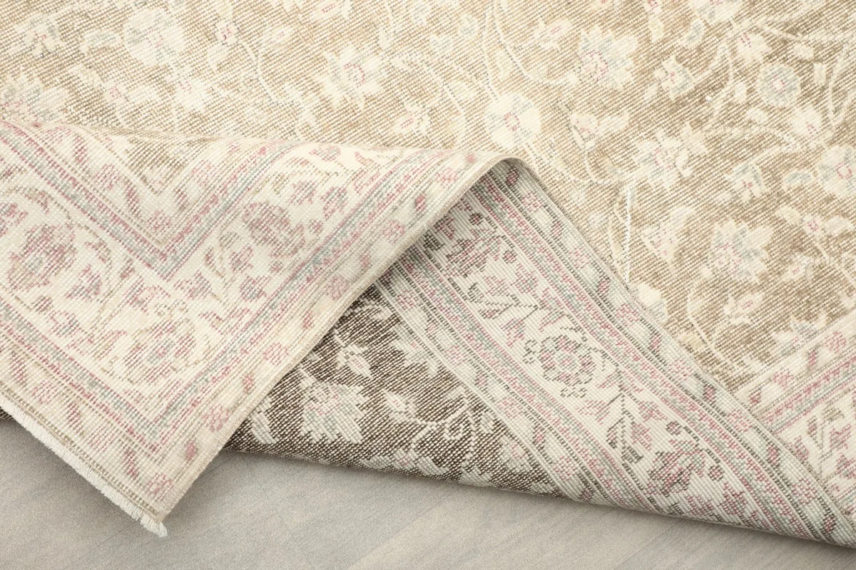 Folded corner of the rug, displaying the backside and the cotton foundation