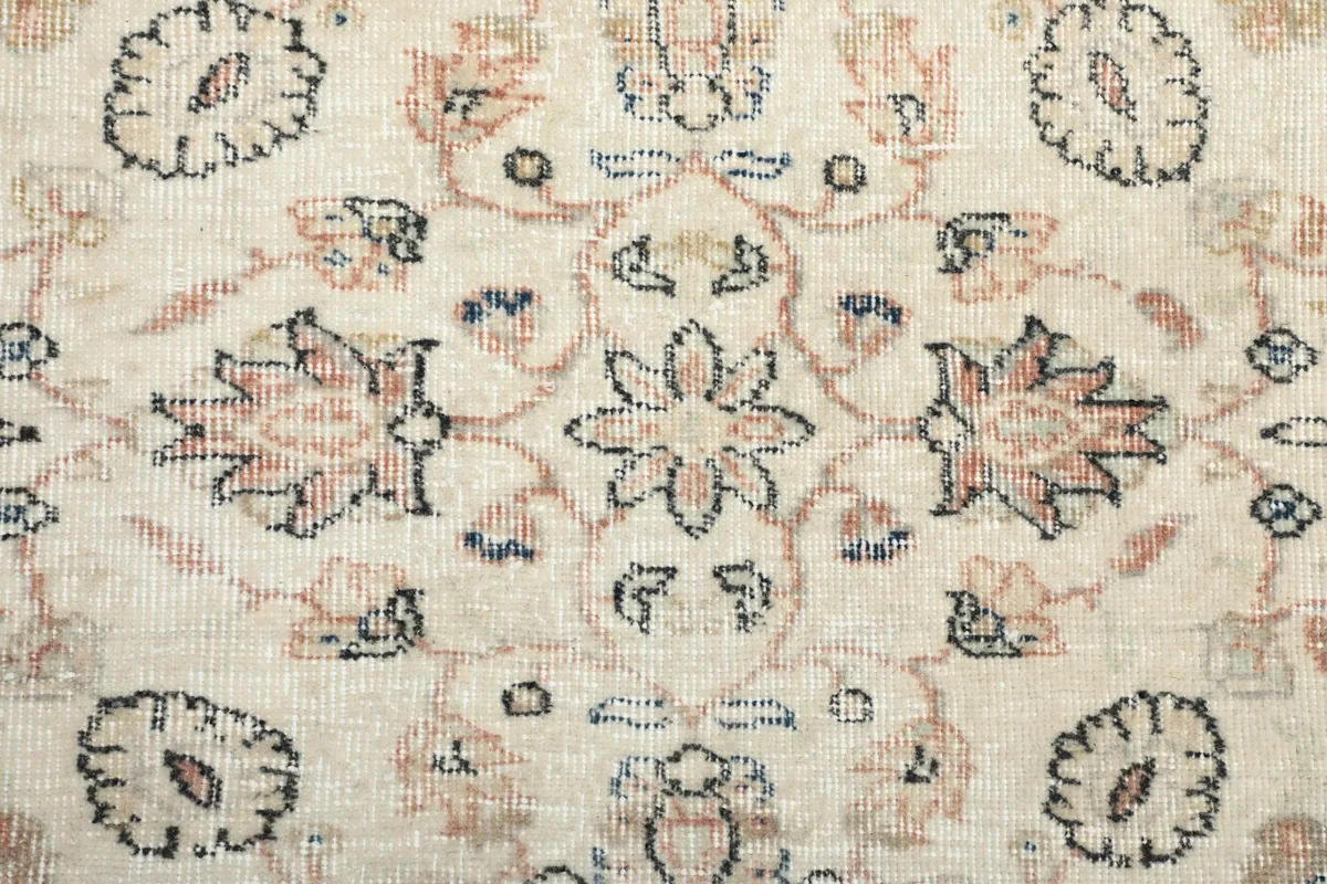 Macro detail of the hand-knotted floral design, revealing the texture and natural wear
