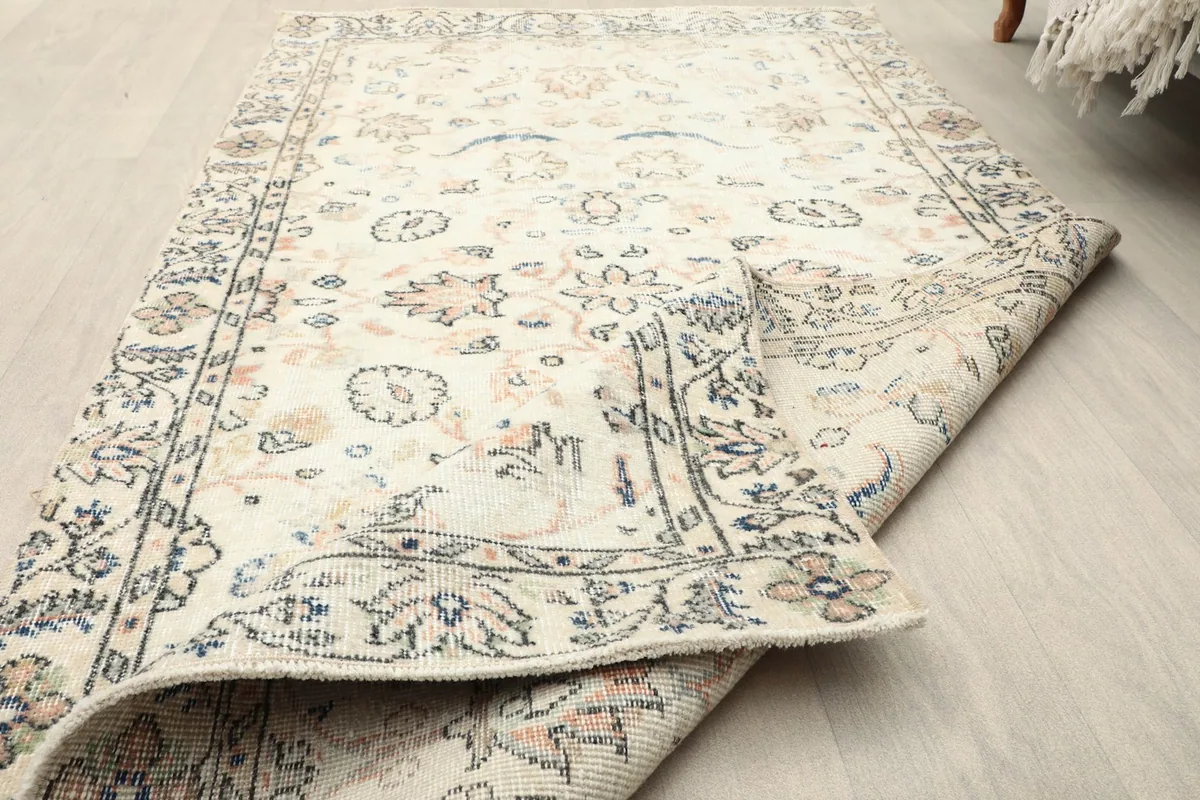Close-up of the rug's low wool pile and folded corner, showing its thickness
