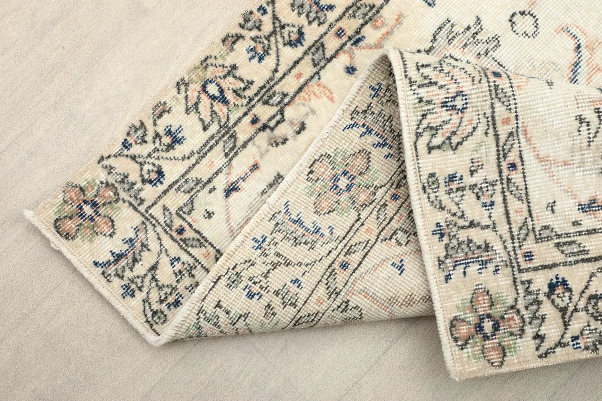 Folded section of the rug, showing the border and field patterns from an elevated perspective