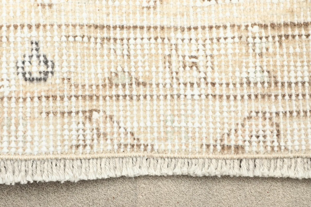 Close-up showing the fringe and edge of the hand-knotted wool pile on cotton foundation.
