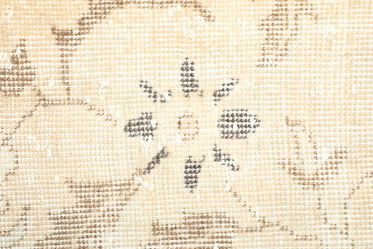 Detailed view of the low wool pile and the intricate knotting of the floral design.