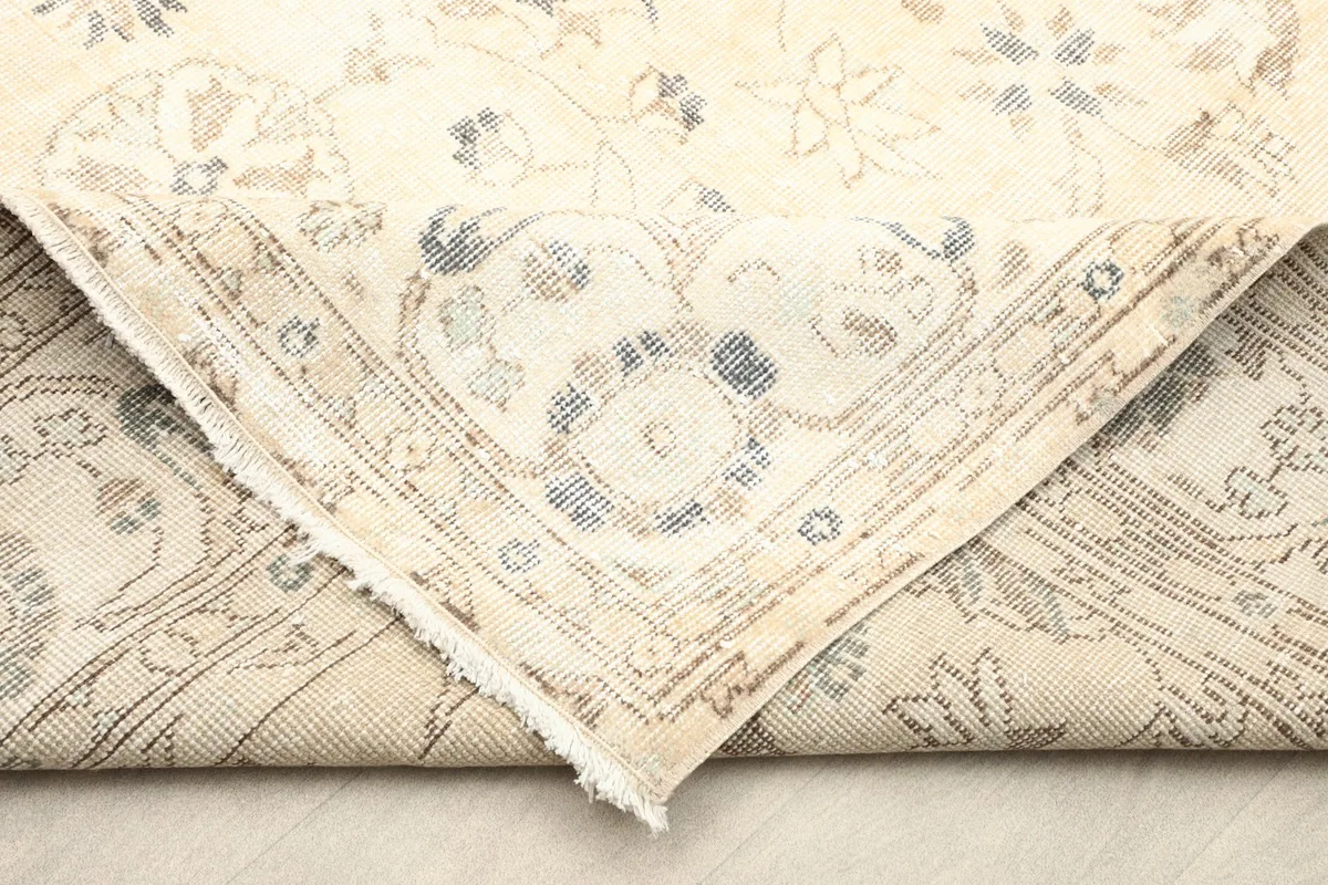 Folded corner of the rug showing the reverse side and the hand-knotted construction.
