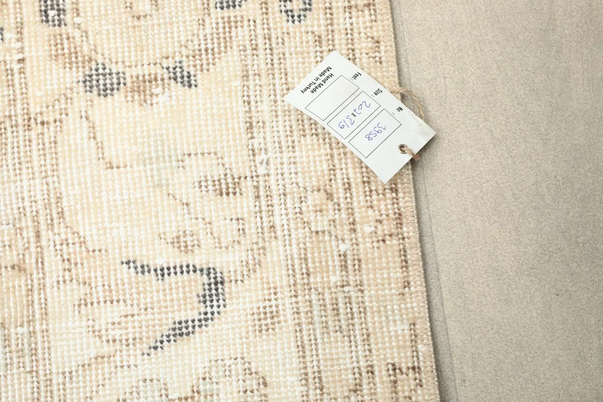 Close-up of the rug's surface next to a product tag displaying item information.