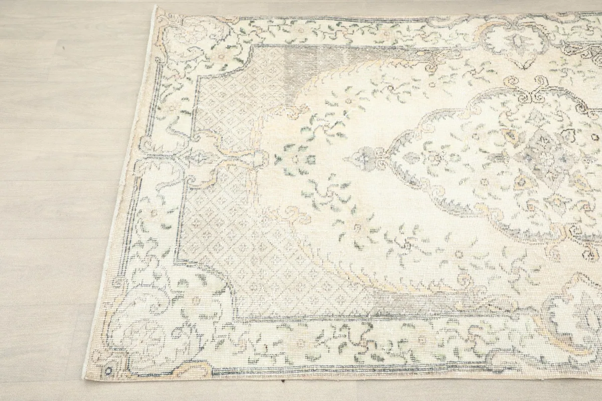 Close-up angle view of the upper left section of the rug, showing detailed medallion and border designs.