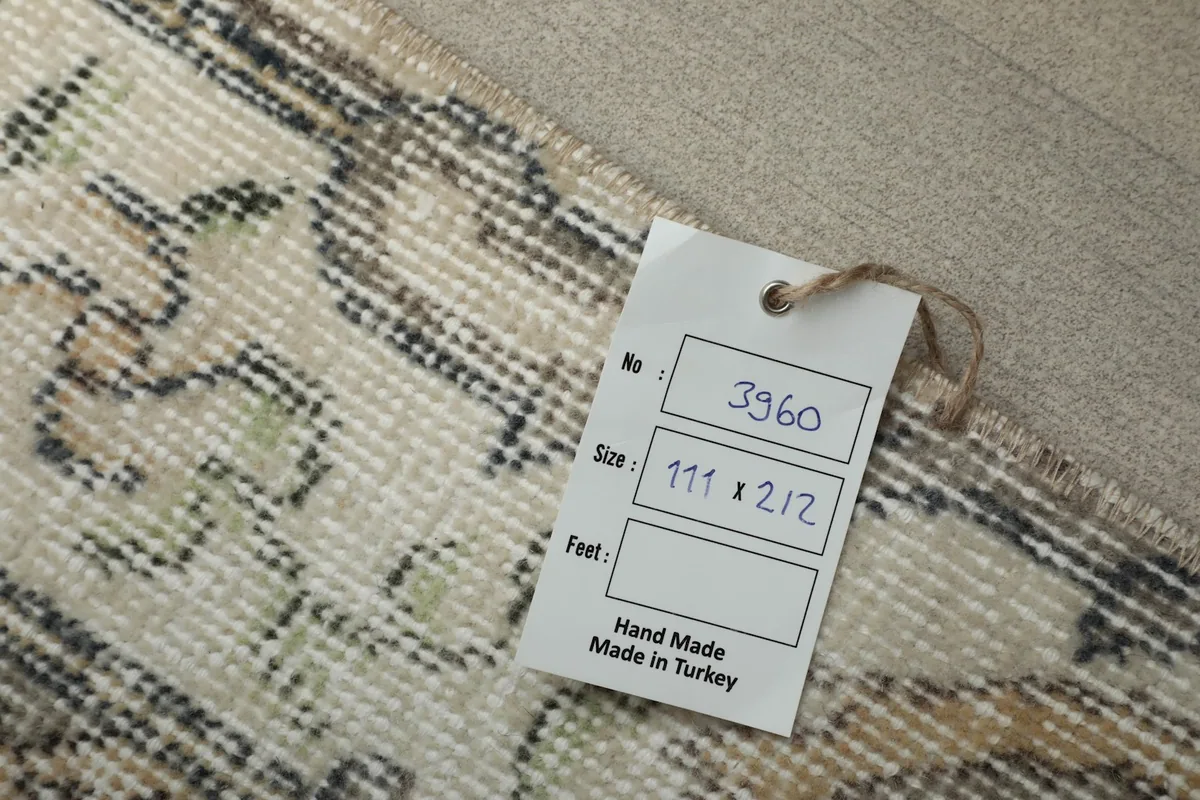 Close-up of the rug's label, confirming it is handmade in Turkey with dimensions 111 x 212 cm.