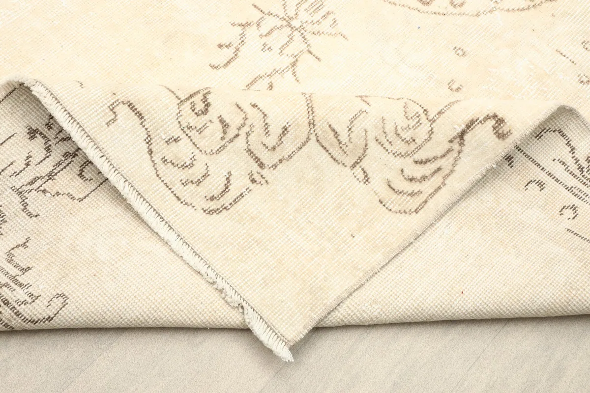 Folded corner of the rug showing the reverse side and the hand-knotted construction.